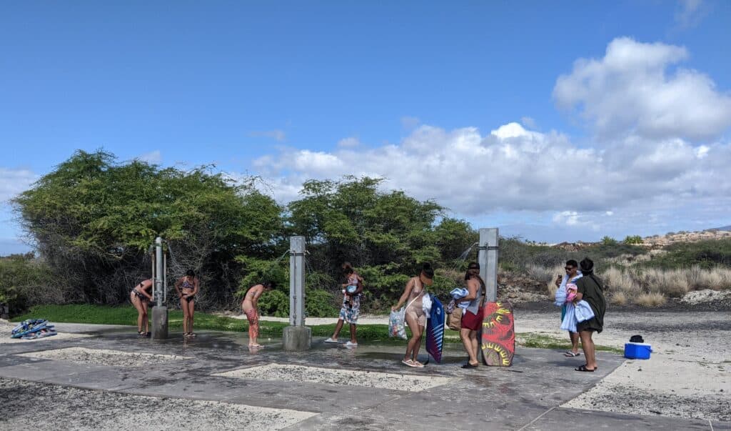 row of outdoor showers at kua bay beach