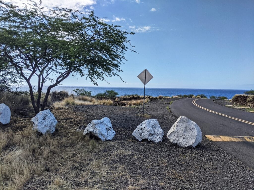 white painted boulders near the trailhead for pu'u ku'ili at kua bay beach