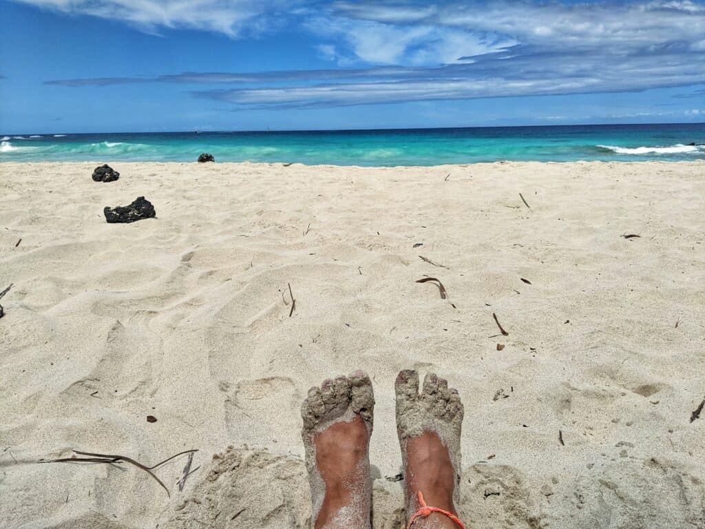 relaxing with feet in the sand at makalawena beach