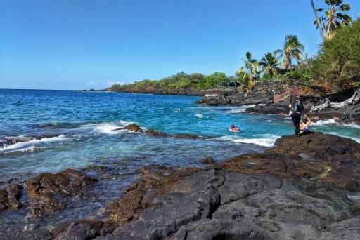 lava rocks by blue water at two step snorkeling spot