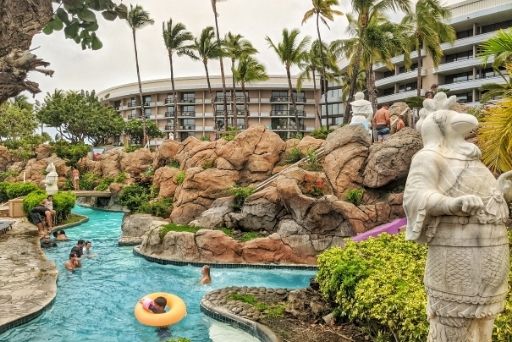 hilton waikoloa hotel pool with rocky boulers and statues