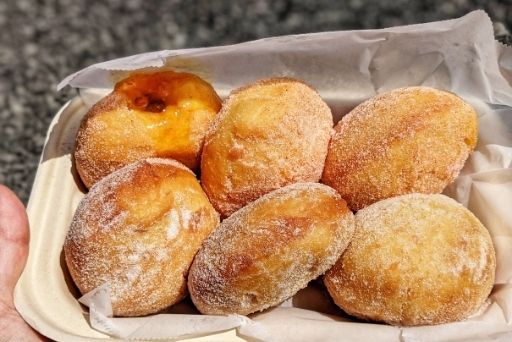 half a dozon Fresh, hot malasadas from the blue food truck