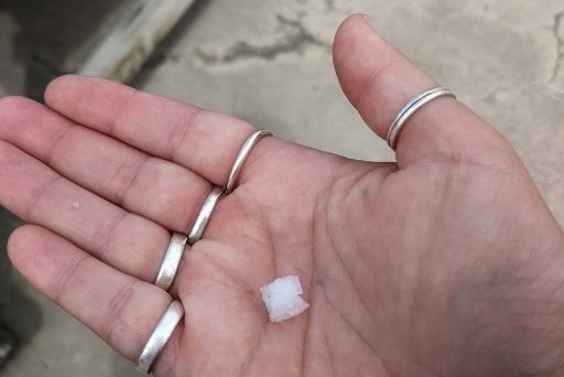 a coarse grain of salt in hand palm at kona sea salt farm