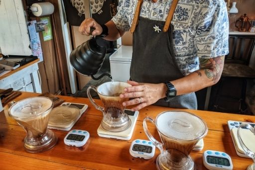 hands making pour over coffee at koana