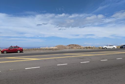 Cars parked along the highway at a trailhead