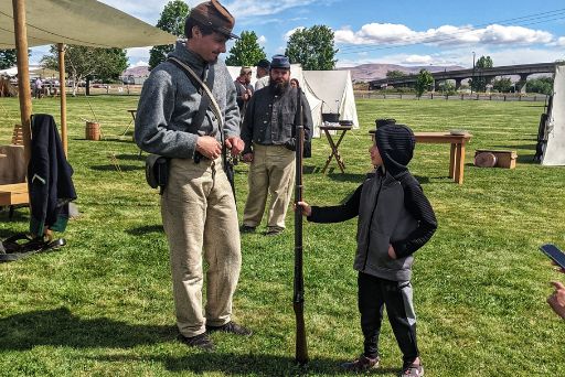 confederate soldier showing gun off to boy at civil war reenactment yakima