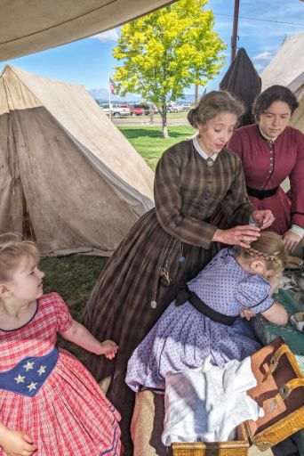 civilian mother doing daughter's hair at civil war reenactment yakima