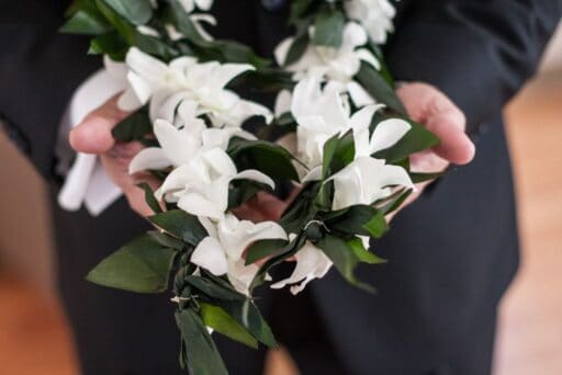 white lei presented by man