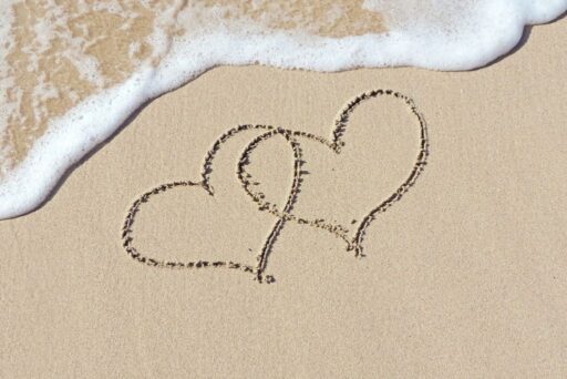 two hearts drawn in sand