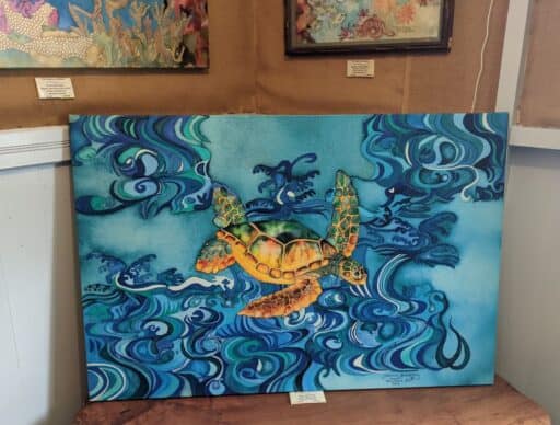 Colorful painted canvas depicting a Hawaiian sea turtle amidst blue ocean waves,