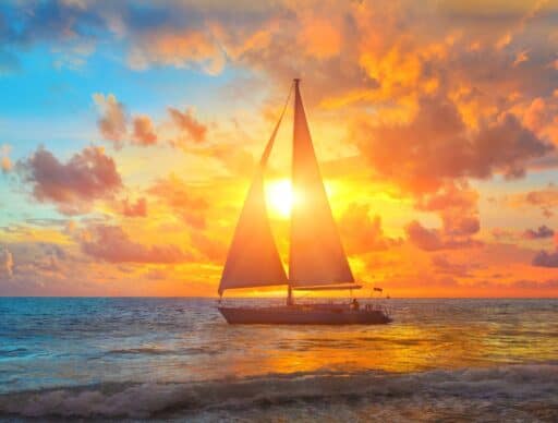 sailing yacht silhouette with sunset. booking a private boat charter is an alternative mode of transportation instead of a ferry from oahu to big island