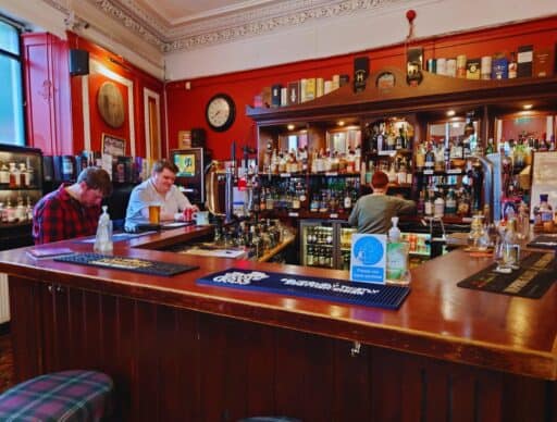 mandy serving up some drinks for customers at the bar inside the curly coo bar