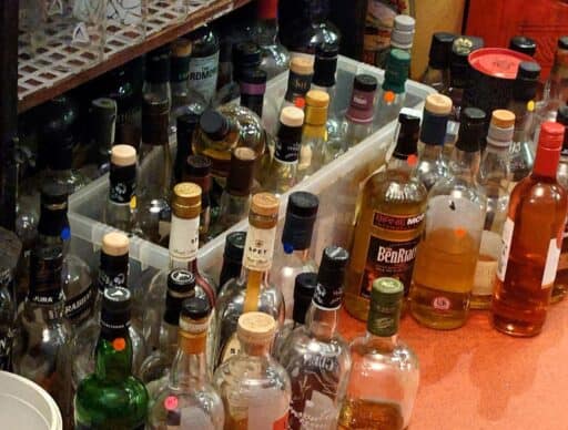 curly coo bar whiskey collection on the floor as there are too many for the shelves