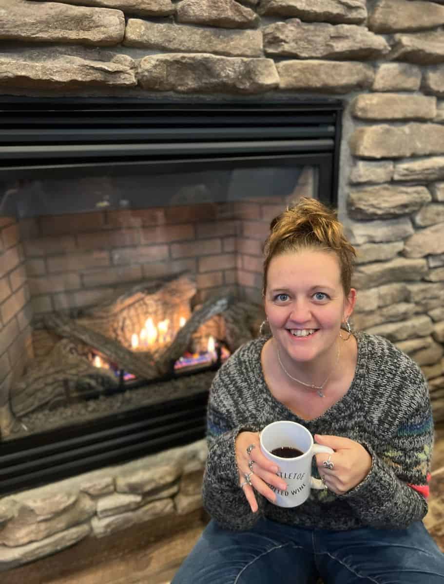 me sitting by the fireplace with a warm cup of gluhwein