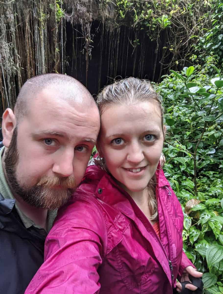 michael and i taking a selfie with a lush, dark greenery background, highlighting rainforest exploration on the Big Island.