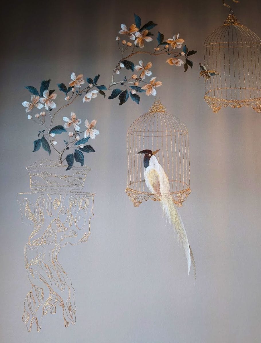 embroidered wallpaper of flowers and a bird in a cage