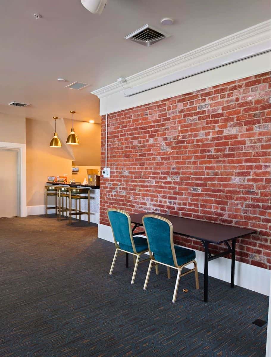 the other side of the event venue room upstairs at the muse with a brick wall