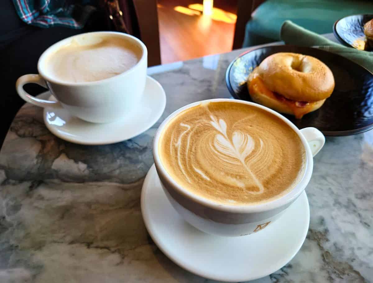 cups of muse coffee and a bagel