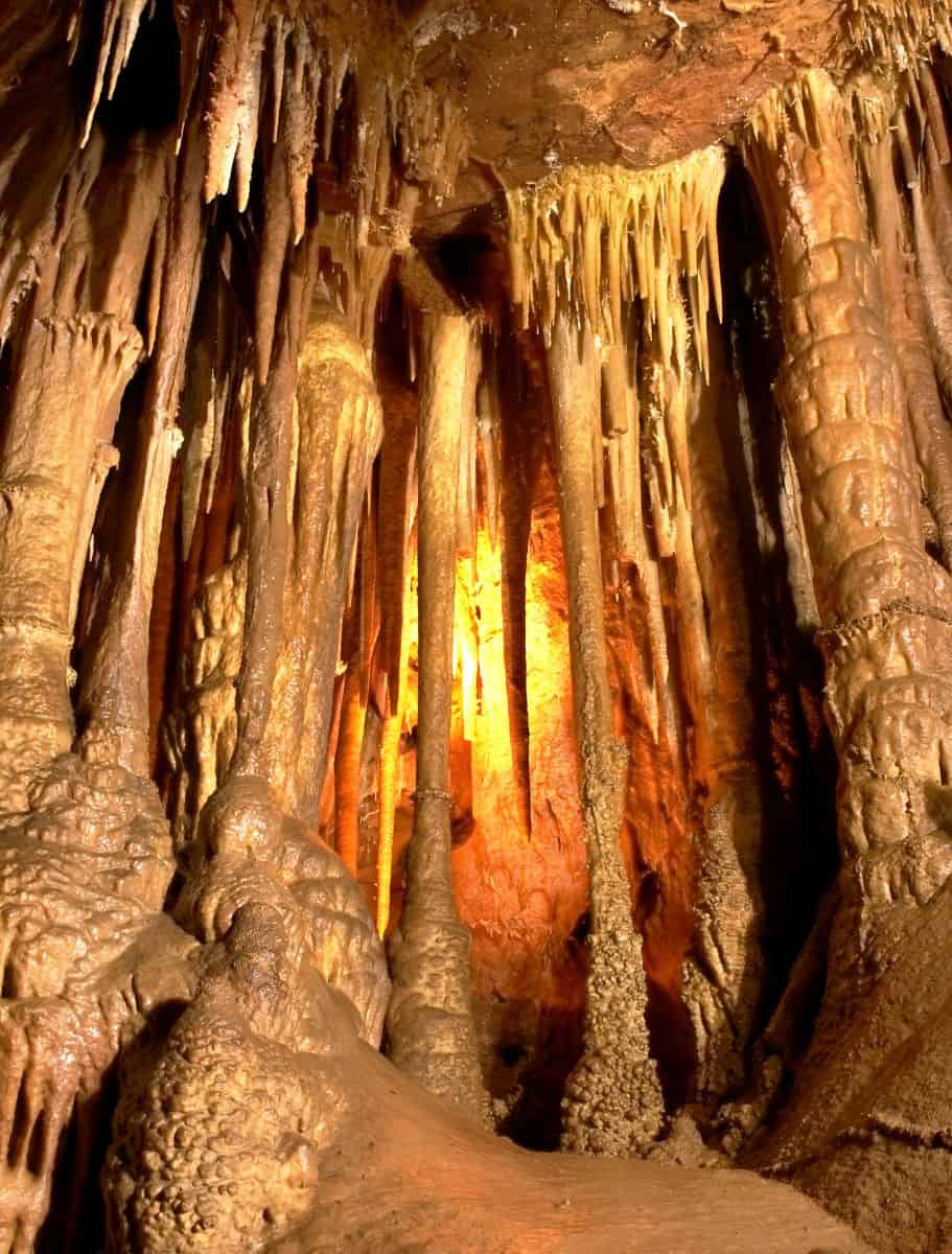 limestone cave with stalagmites and stalagtites with orange light in the middle