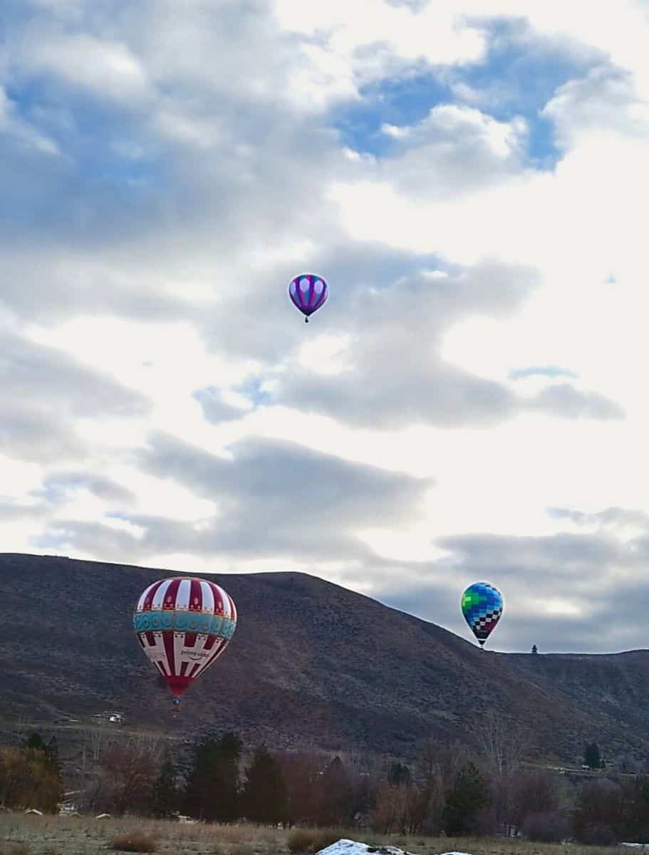 Colorful Winthrop hot air balloons floating gracefully with a scenic mountain landscape in the background,