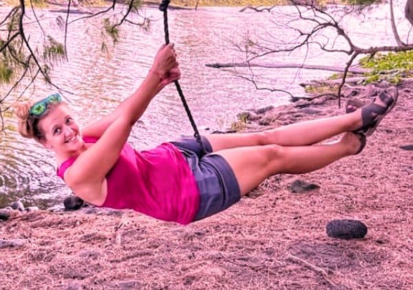 me swinging on a rope swing with water in the background