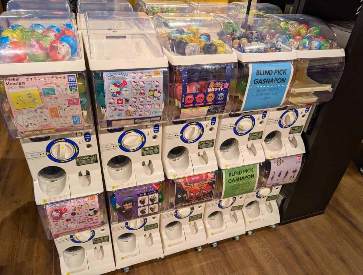Rows of colorful Japanese gashapon capsule toy machines filled with anime and character collectibles inside a specialty shop in Oak Harbor. Visiting quirky local shops and browsing imported collectibles is one of the unique things to do in Oak Harbor for anime fans and families.
