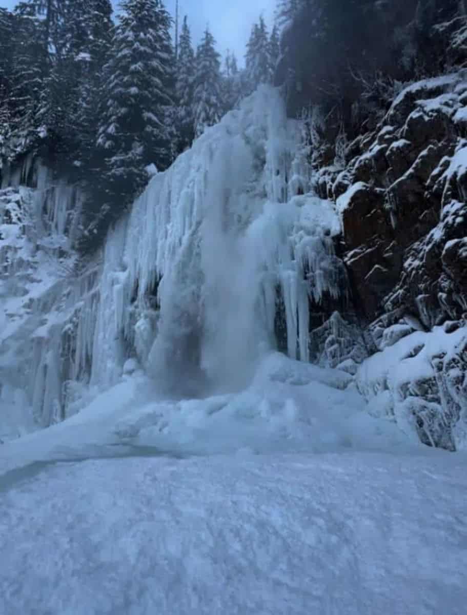 frozen Franklin Falls with snow in forground and covering cliffside