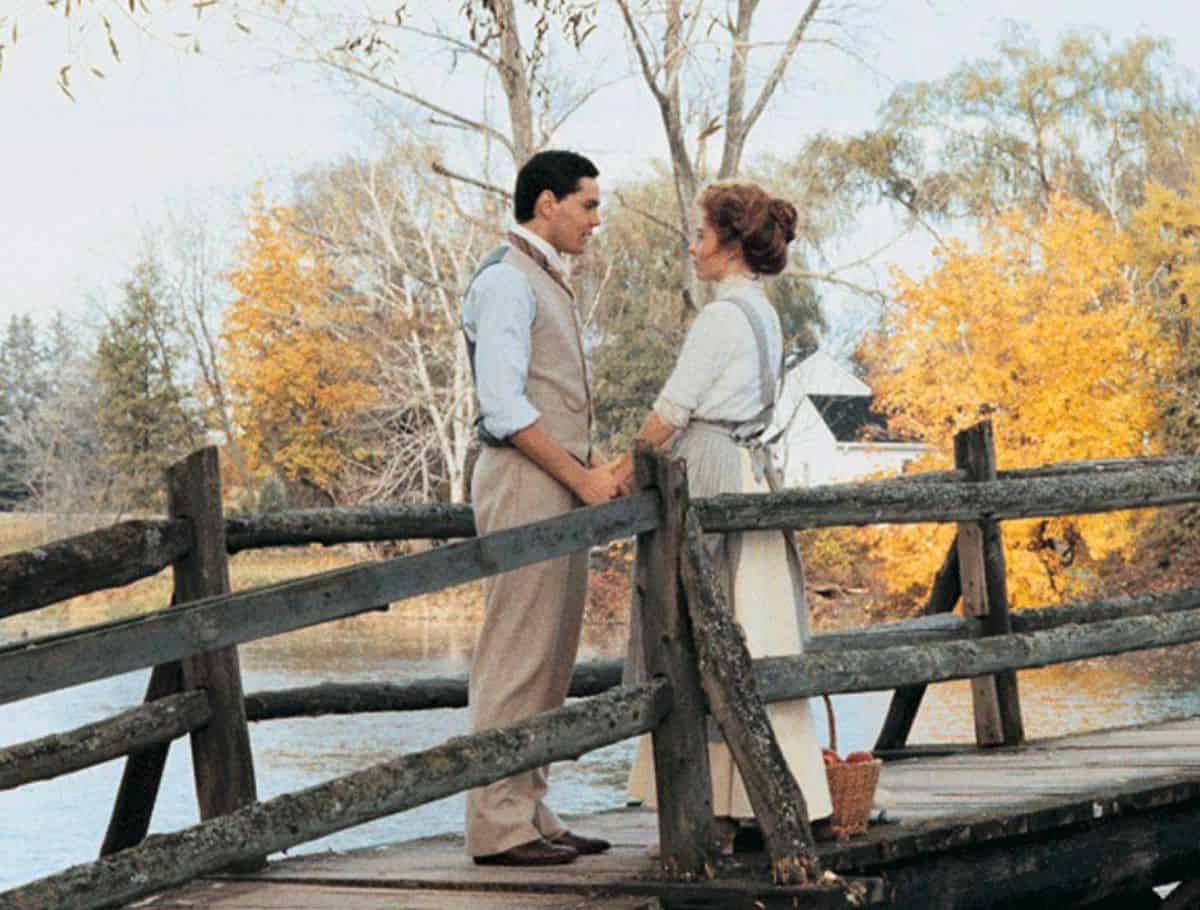 Anne and Gilbert sharing a moment on the wooden bridge during autumn in Anne of Avonlea