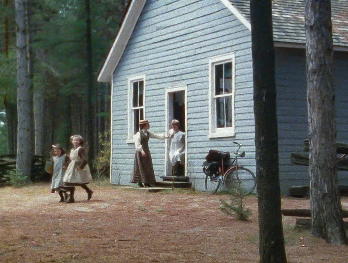 scene from anne of green gables of the exterior of the schoolhouse in the woods