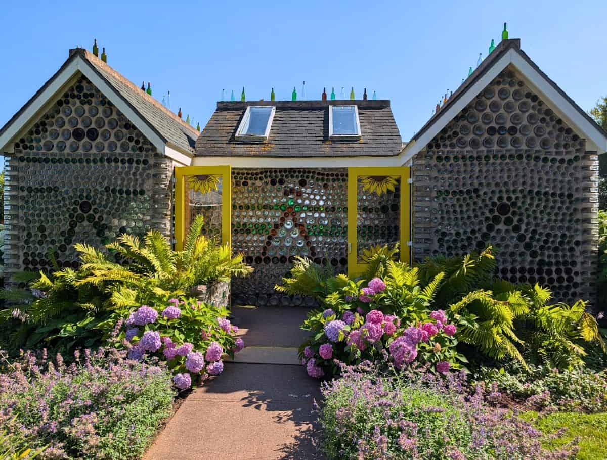Six gabled glass bottle house at The Glass Bottle Houses and Gardens with sunflower doors