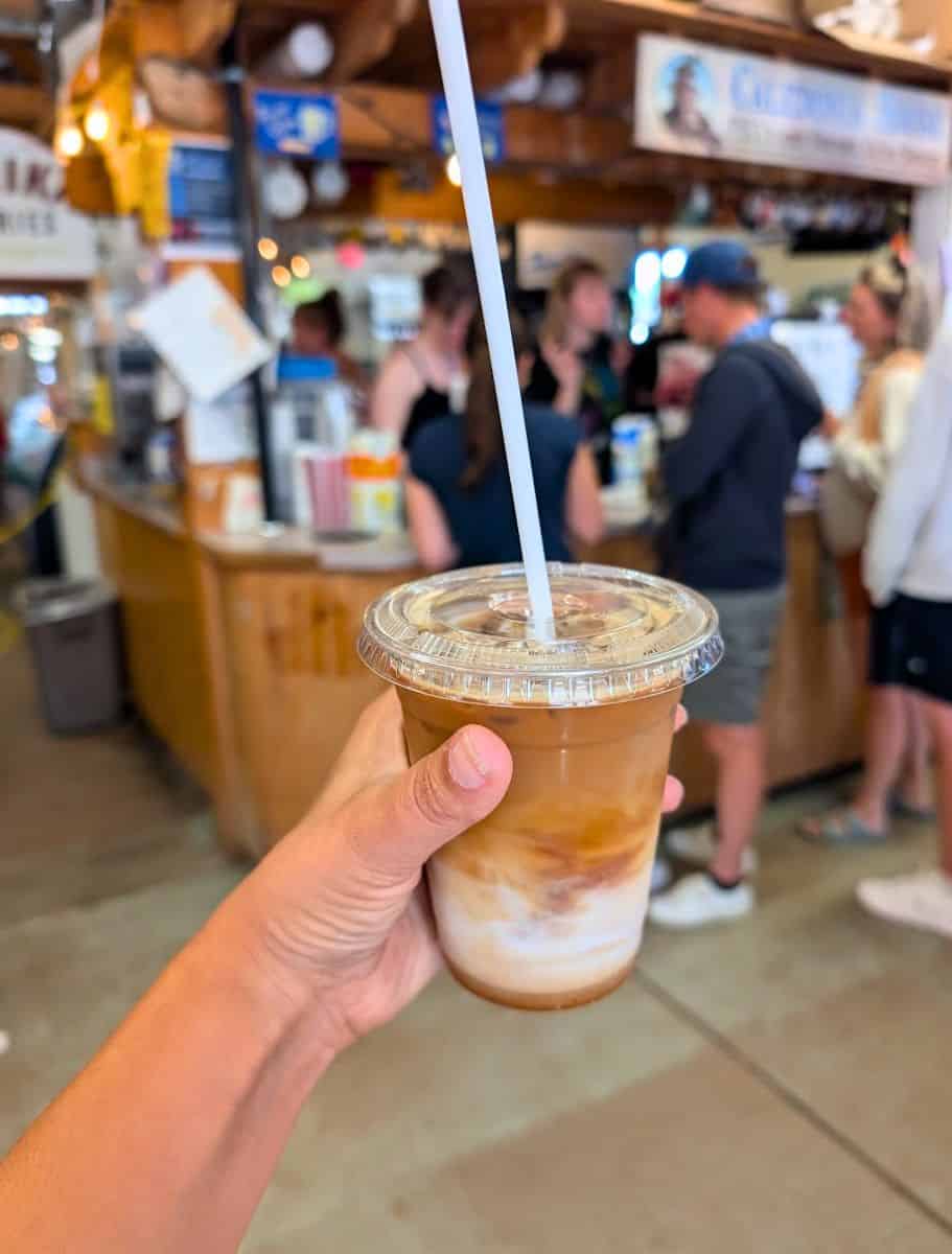 my hand holding Iced latte from Caledonia House