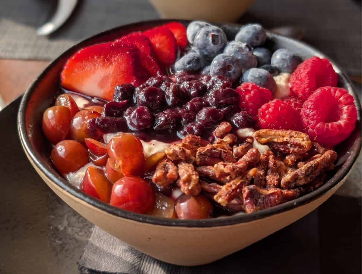 large bowl of steel cut oats covered in toppings of nuts and berries