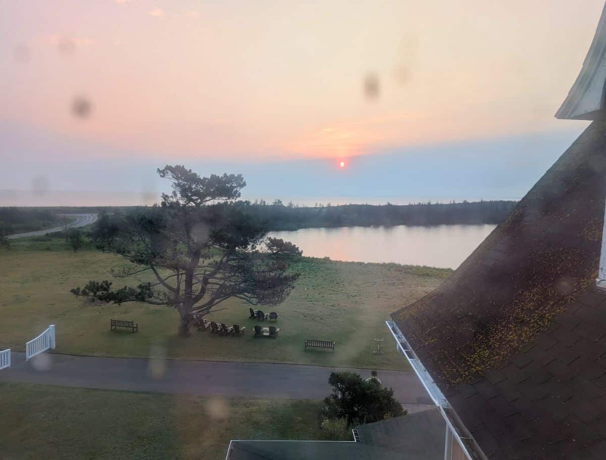 My obscured water view of lake and ocean at sunrise from my room with dirt and cobwebs fuzzing up the window
