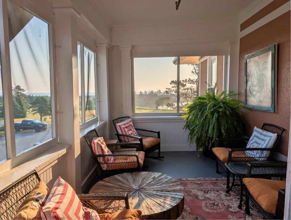 Open-air, screened-in porch on the second level with wicker patio furniture