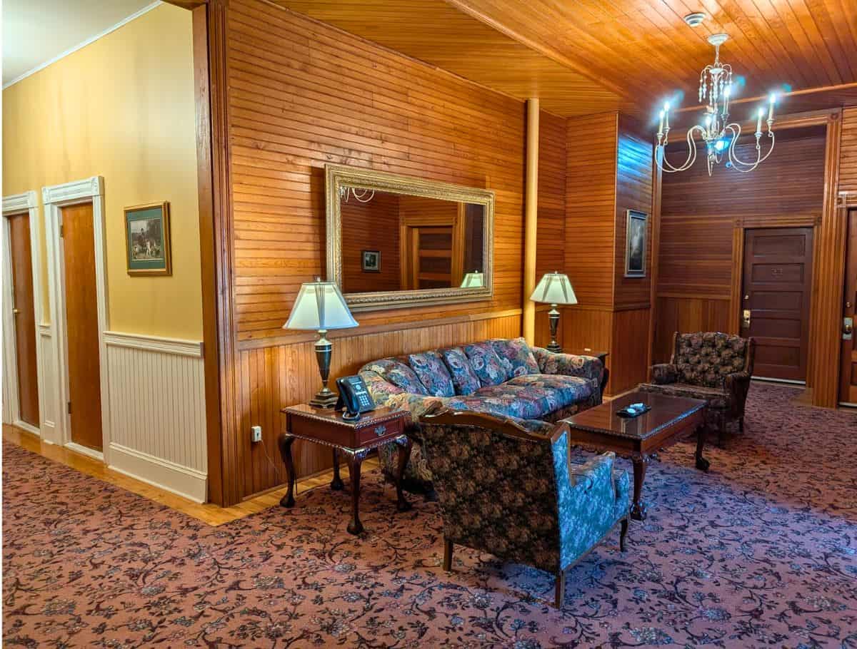 couches in Sitting area in the hallway with floral carpet