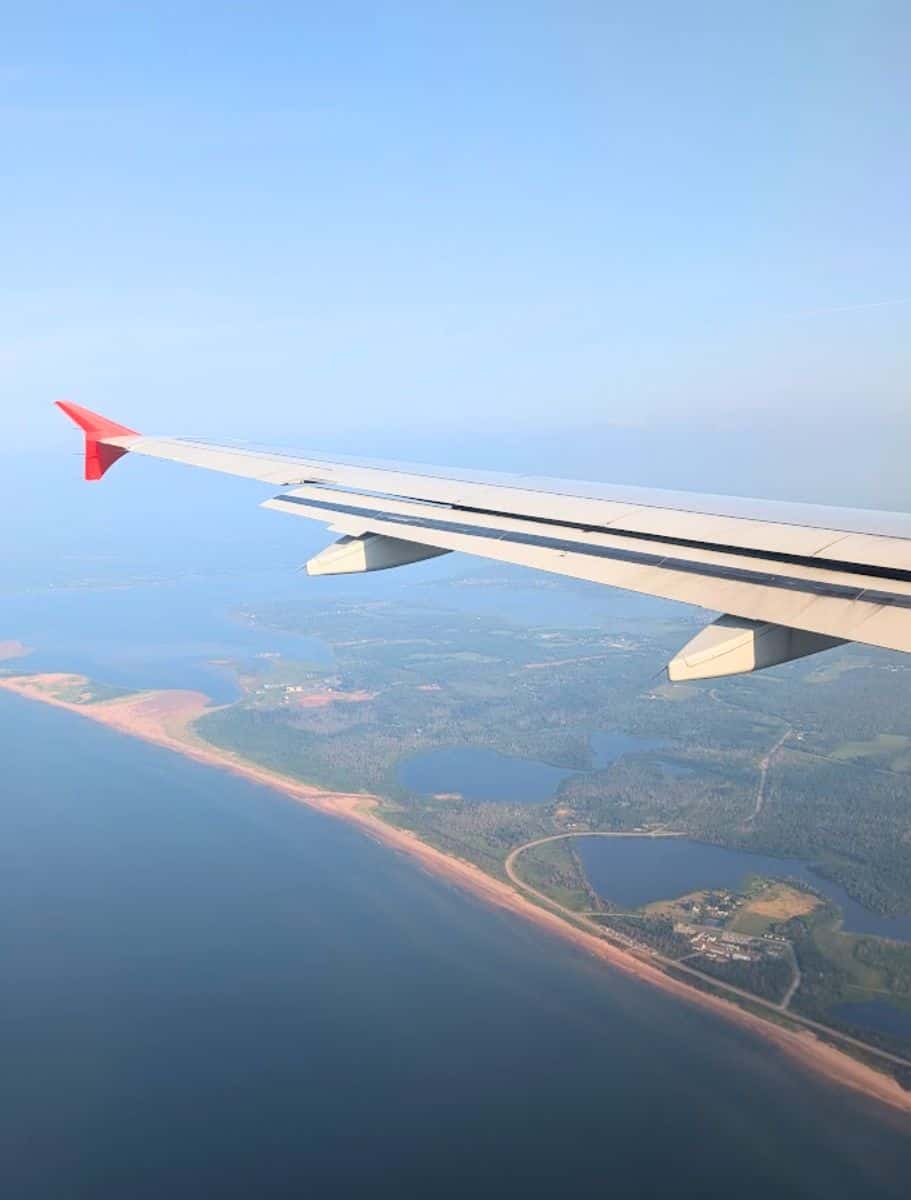 view flying over dalvay by the sea from my airplane window, wing in the shot. you can see the coast and lakes and property clearly
