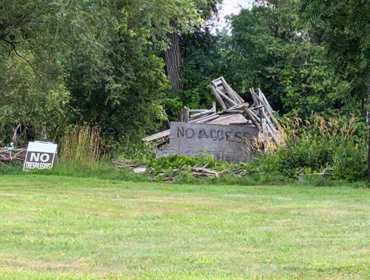 No access and No trespassing signs block the pile of wood that used to be the bridge used as a film location for the anne movies
