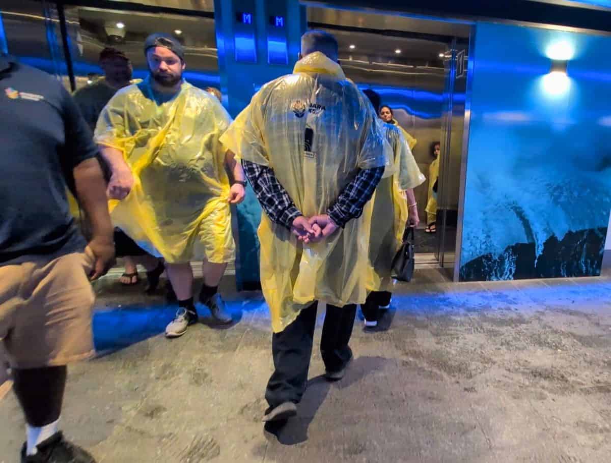 Elevators crammed with visitors all suited up in ponchos filling and leaving the elevators