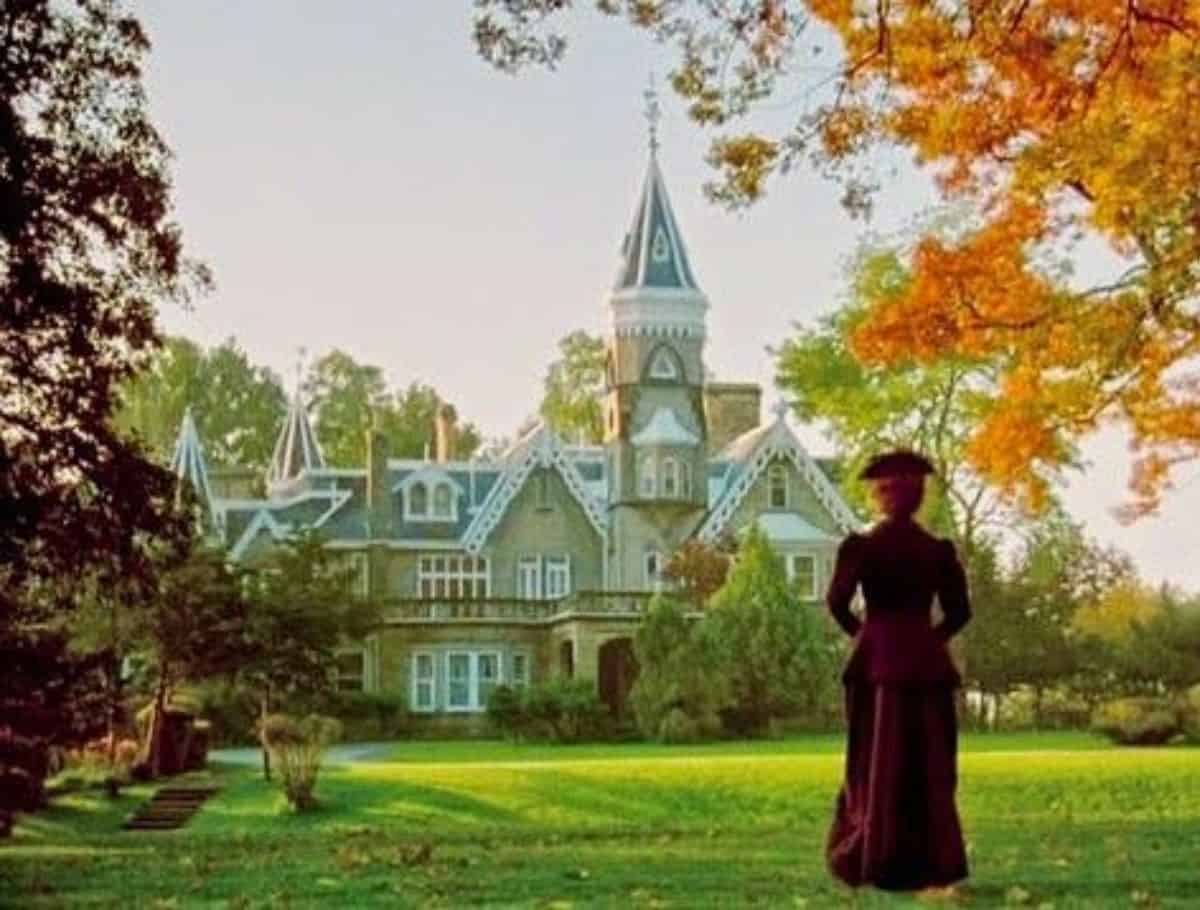 Scene of Anne approaching Maplehurst with her in foreground and house with spire in background