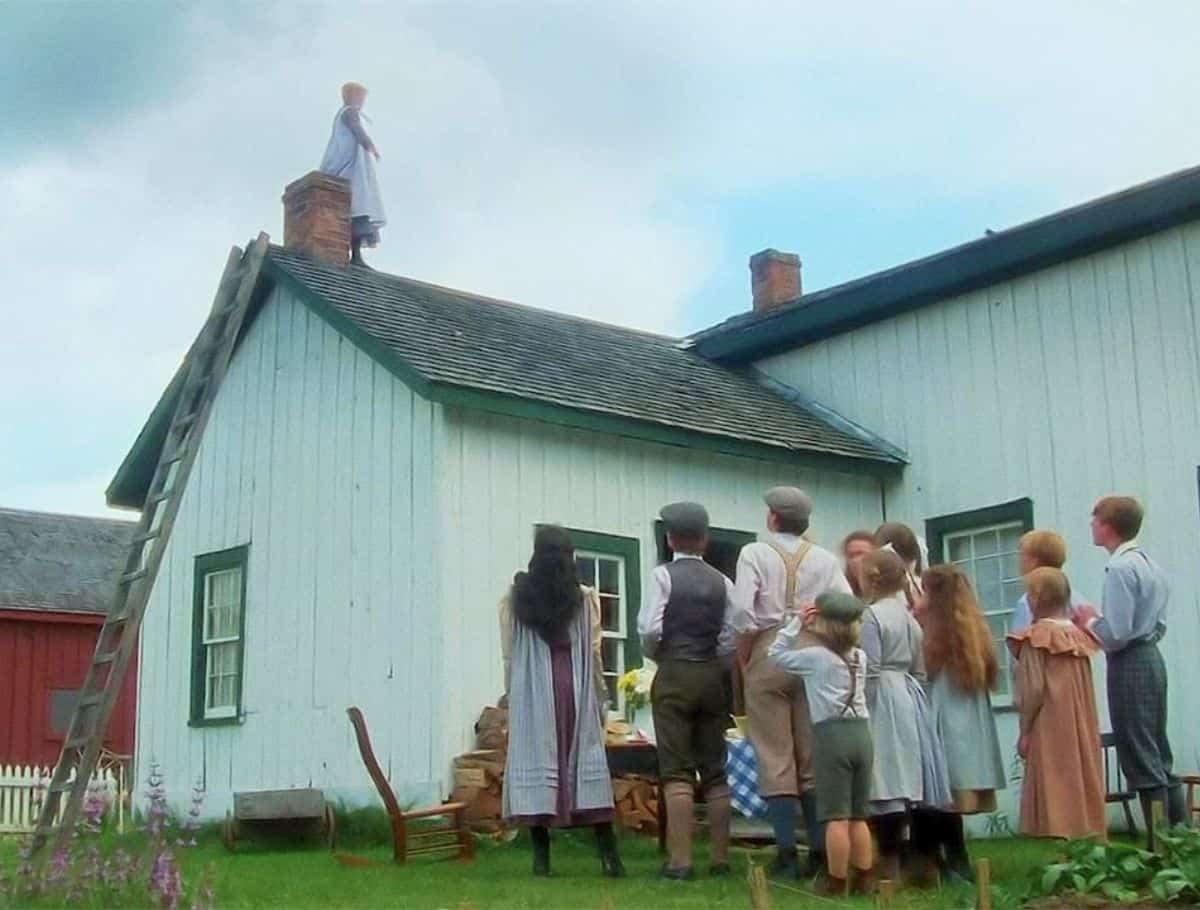 movie Scene of Anne walking Moody's roof ridegline as students look on from the ground