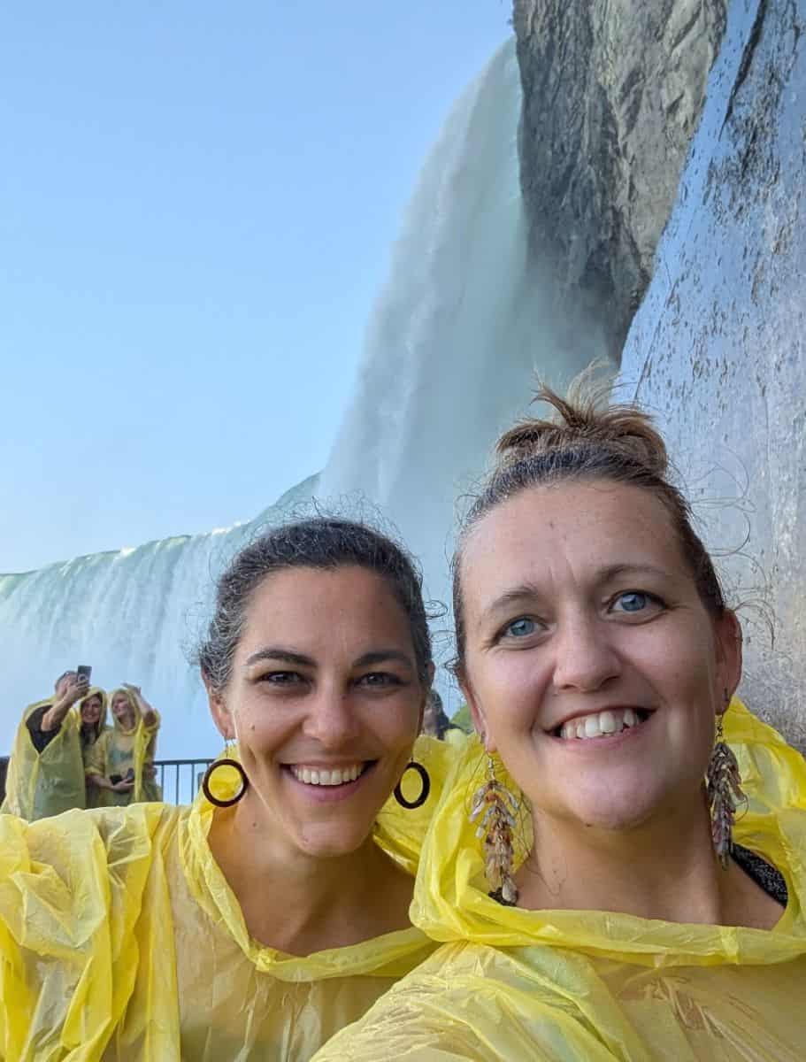 Selfie in front of the falls with other people taking selfie in background. all of us in yellow ponchos