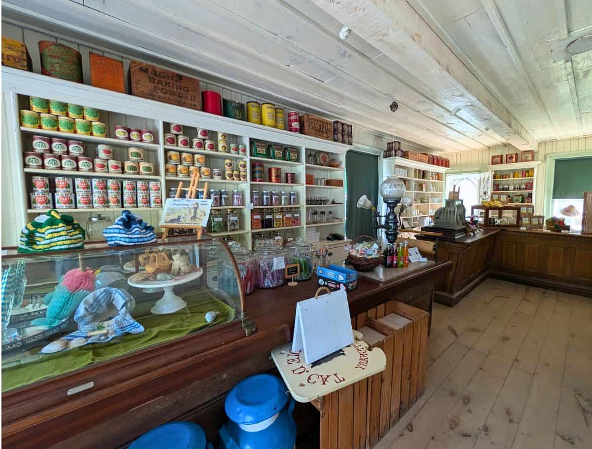general store interior at westfield heritage museum. shelves stocked with period cans of food and historic counters fills with candy and goods.
